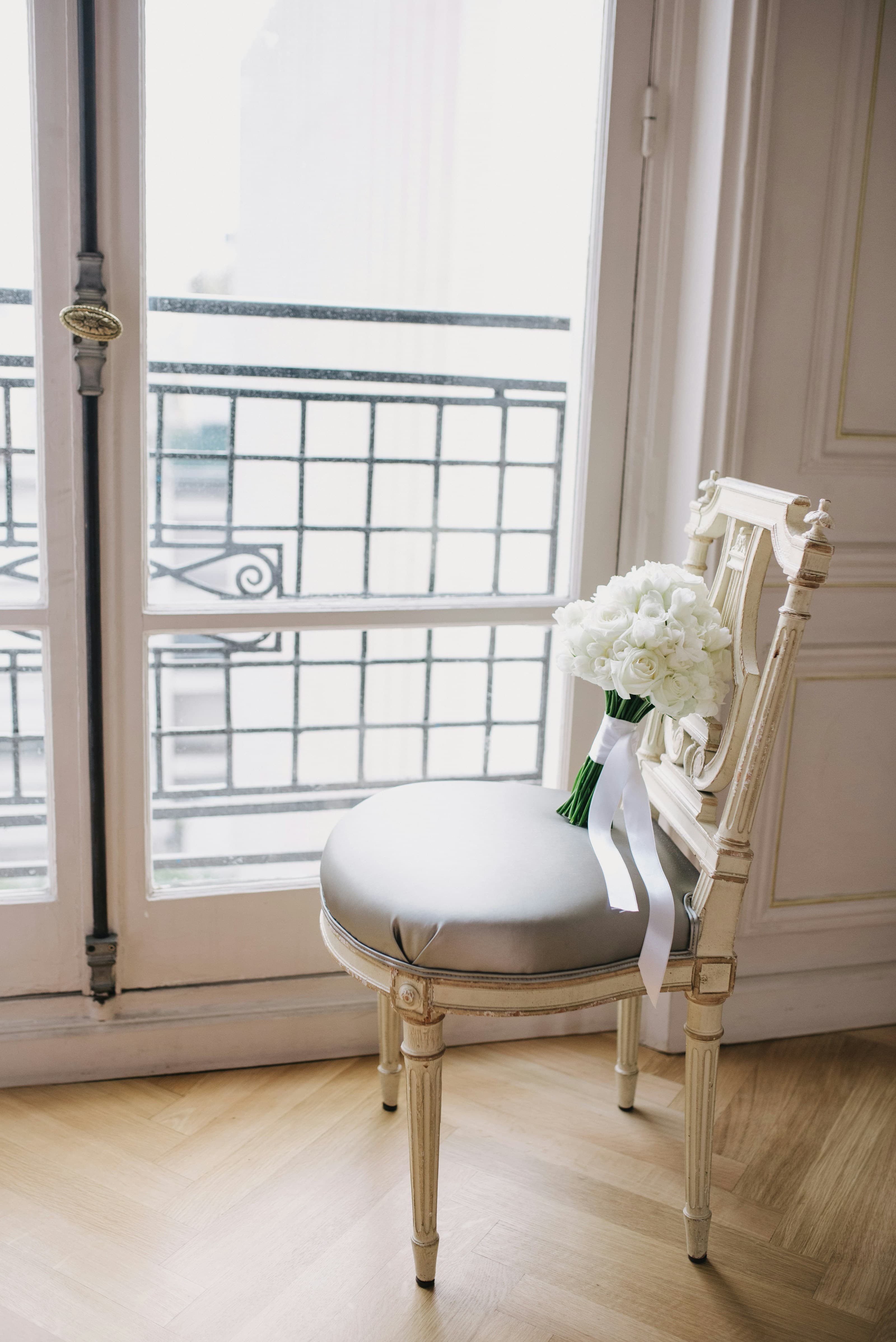 Fauteuil ancien devant une porte-fenêtre dans un appartement lumineux